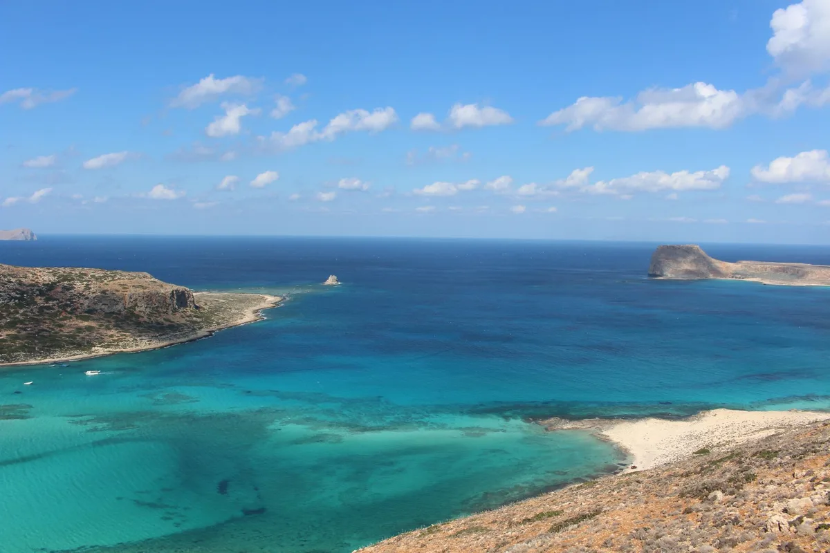 Paysage côtier crétois avec maisons blanches et mer turquoise