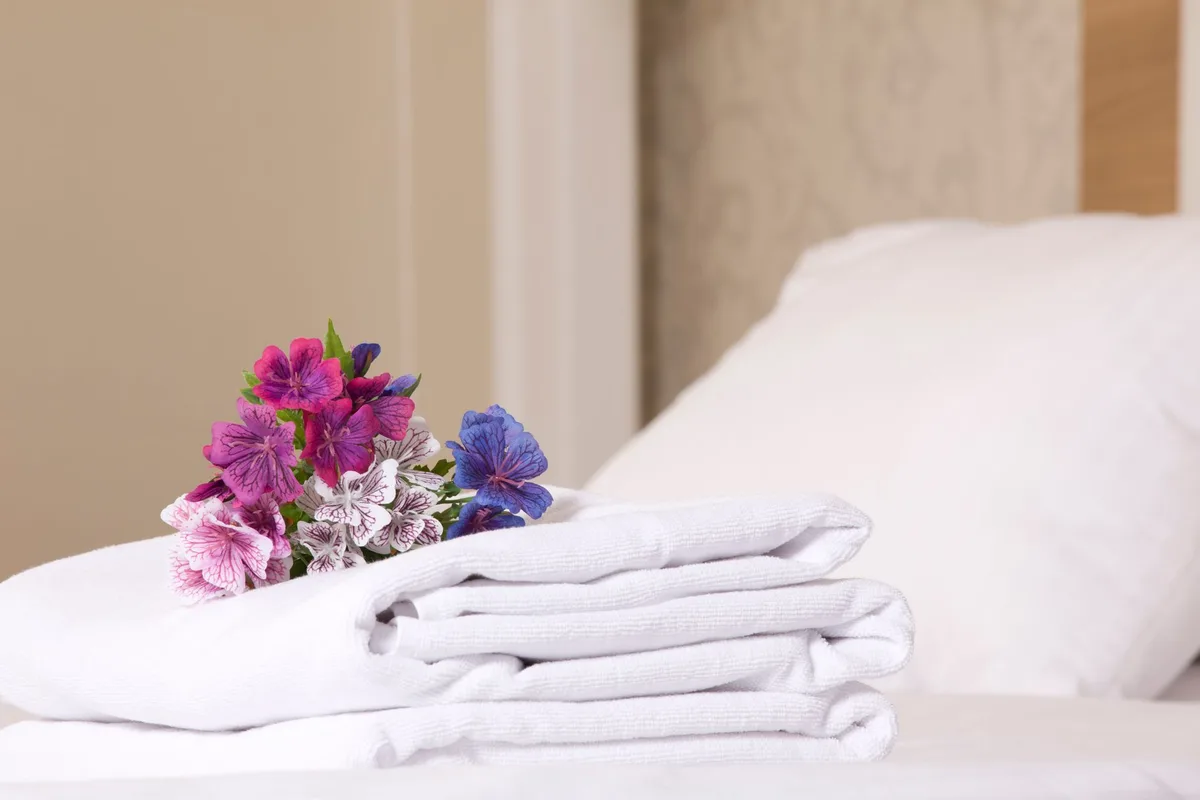 Couette gonflante blanche sur un lit bien présenté avec oreillers moelleux et linge blanc impeccable