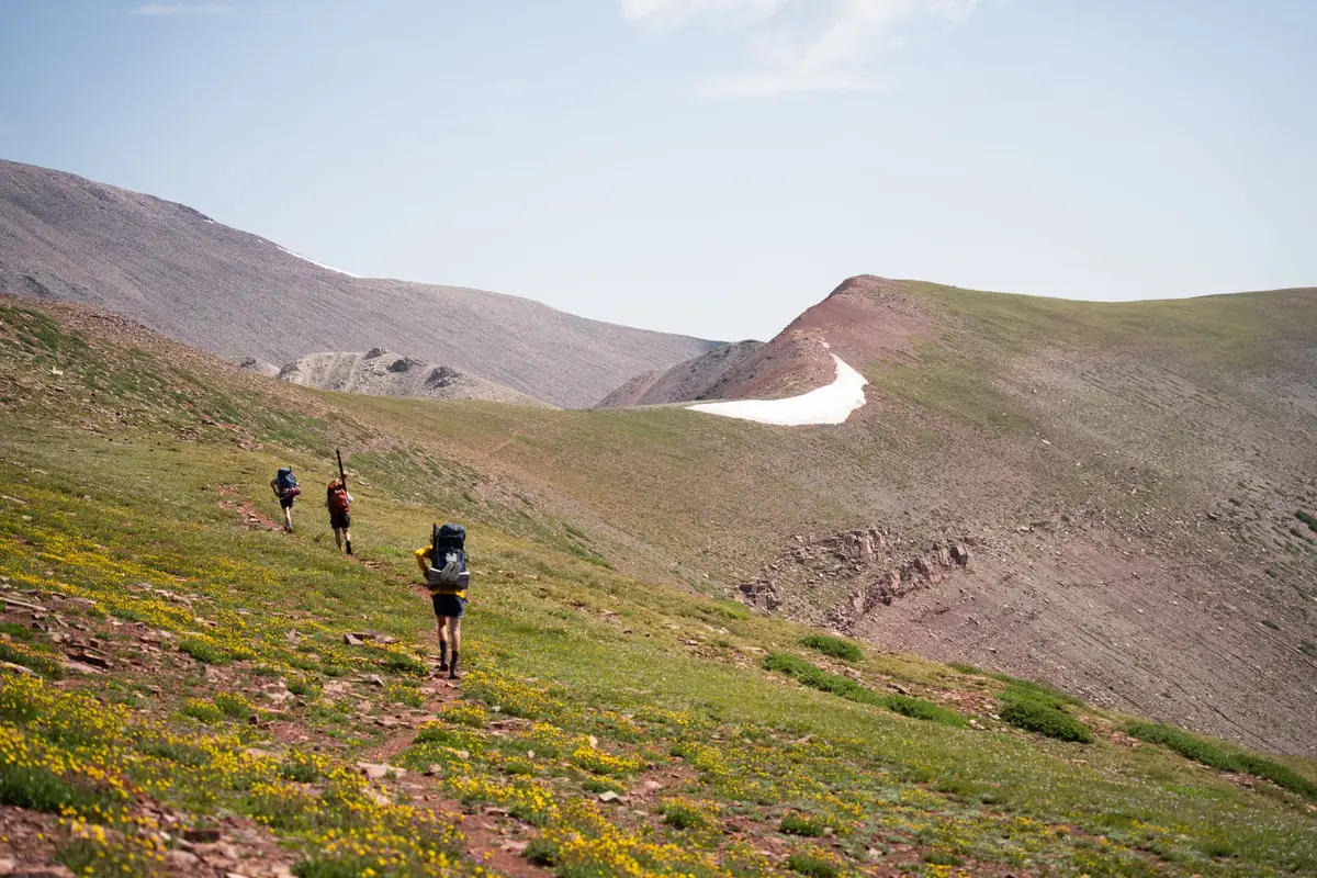 Randonneur portant un sac à dos bien ajusté sur un sentier de montagne