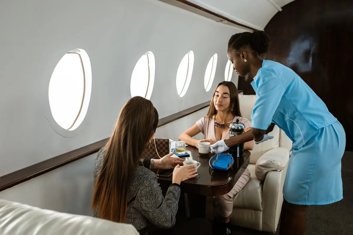 Personnel de cabine servant des boissons aux passagers assis