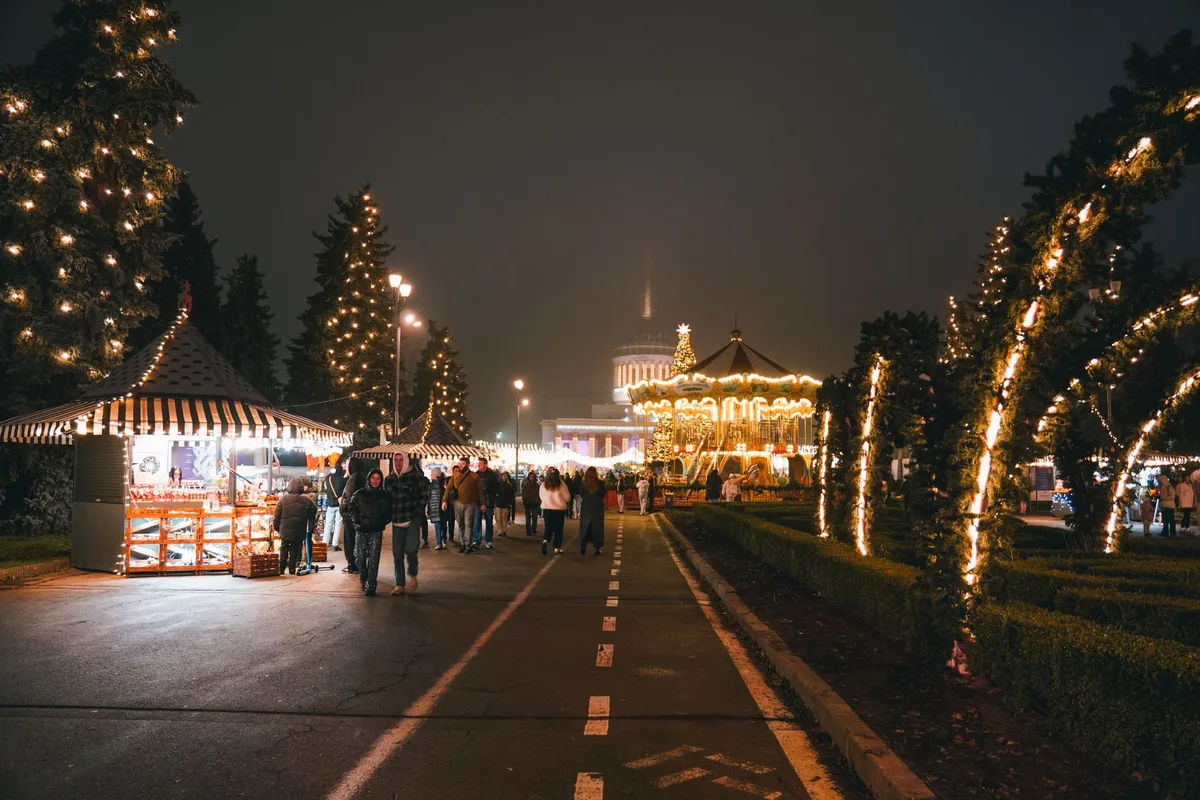 Paysage hivernal européen avec montagnes enneigées et illuminations festives en arrière-plan