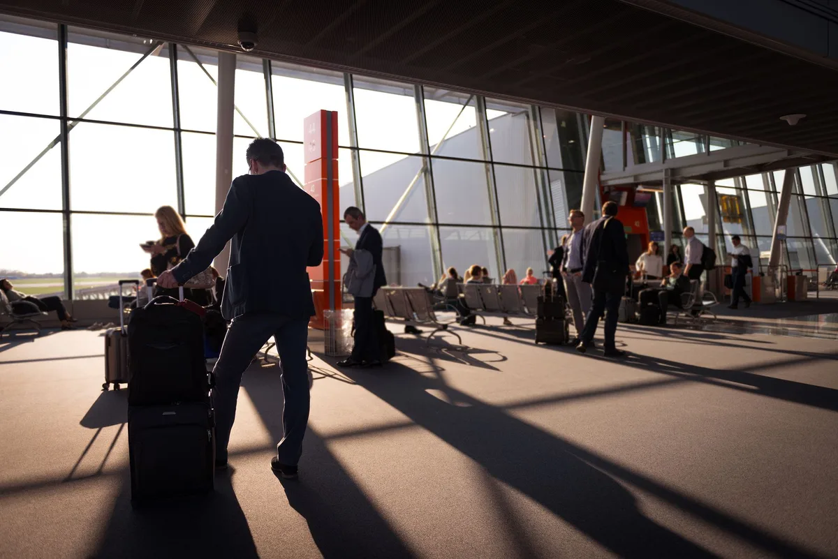 Voyageur avec bagage cabine optimisé se déplaçant rapidement dans un terminal aéroport