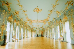 Chambre élégante avec lustre en cristal, mobilier de velours et vue sur les jardins du château