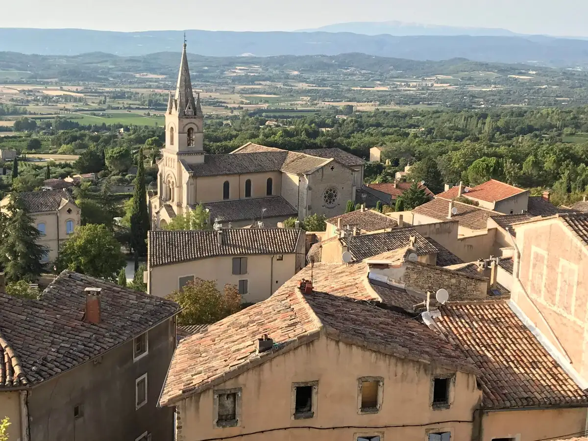 Rues pavées et murs historiques d'une ville médiévale provençale baignée de lumière dorée