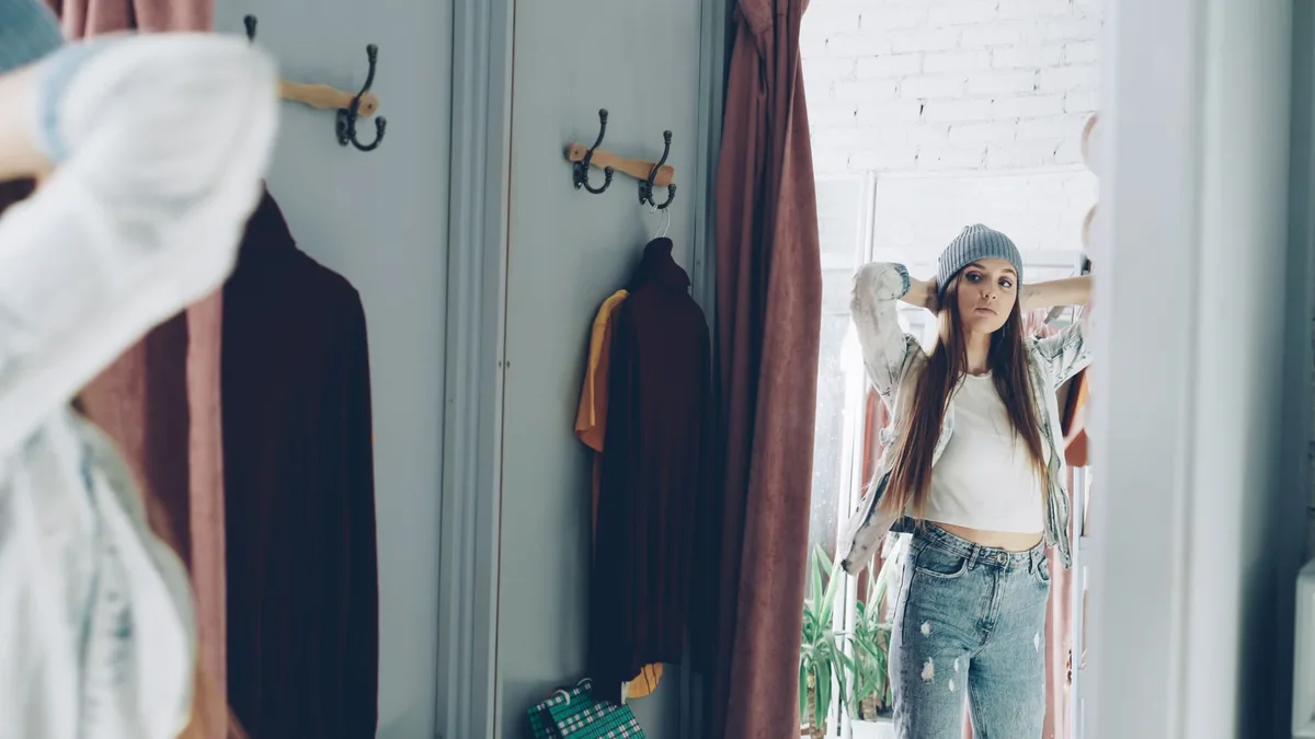 Femme essayant un jean avec ourlet brut pour vérifier la longueur
