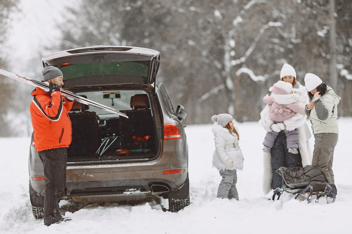 Valise ouverte avec équipement de ski, vêtements thermiques et accessoires d'hiver
