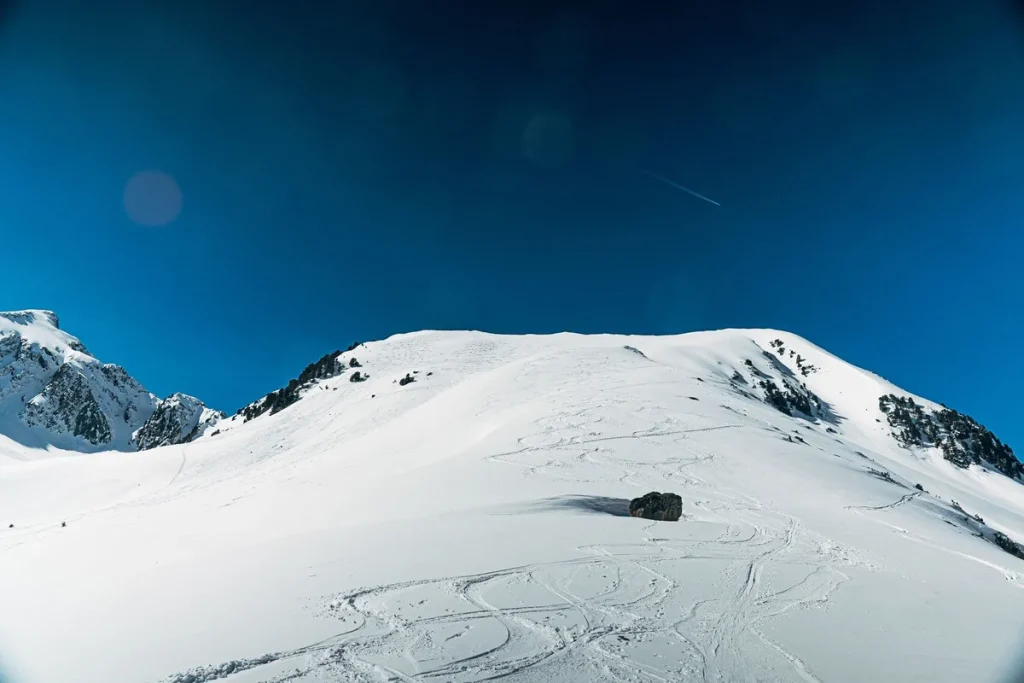 Skieur seul descendant une pente enneigée au lever du soleil sur une montagne de Niseko