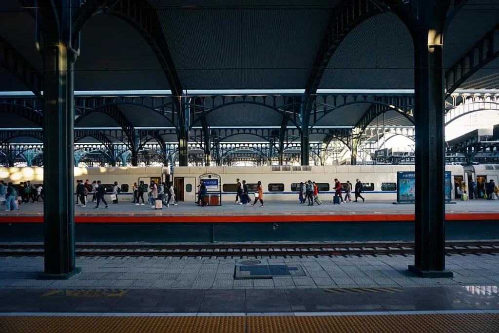 Mains d'une personne âgée tenant un billet de train et une pièce d'identité en gare