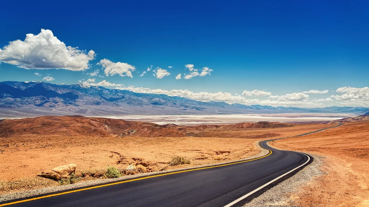 Route secondaire non asphaltée menant vers une ville fantôme en Californie