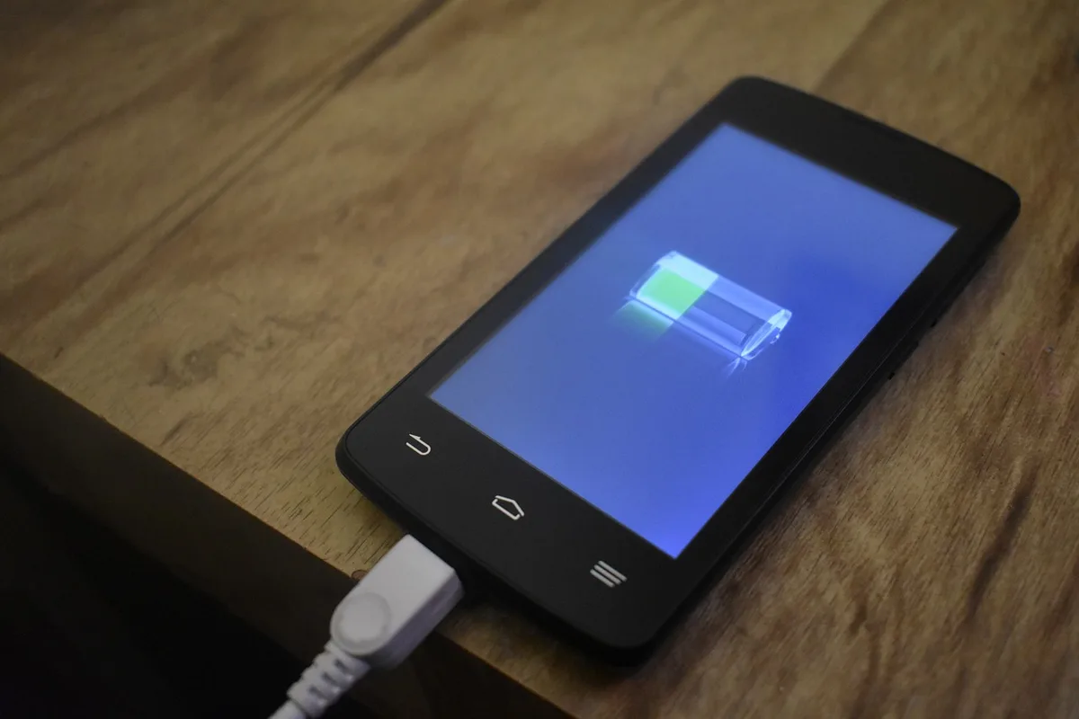 Personne ajustant la luminosité d'un smartphone près d'un powerbank