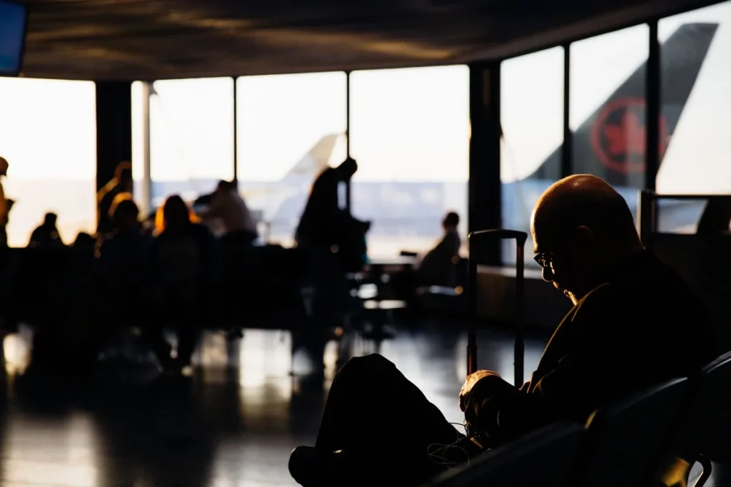 Voyageur à un contrôle de sécurité aéroportuaire préparant son bagage et ses documents
