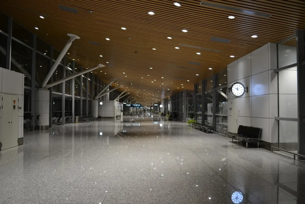 Mains d'un voyageur tenant une carte d'embarquement et un passeport à un comptoir d'aéroport