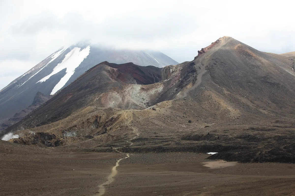 Voiture de location circulant sur une route de gravier à travers un paysage volcanique désert
