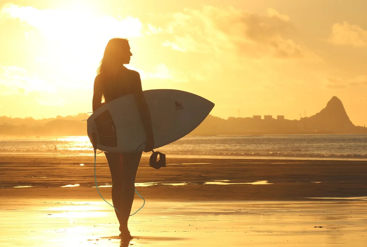 Moniteur de surf donnant un cours à un débutant sur une plage de sable calme
