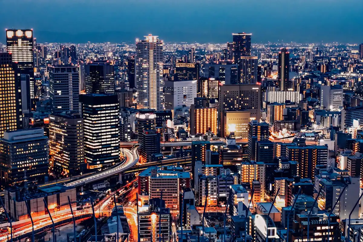 Vue panoramique d'une métropole illuminée la nuit depuis une fenêtre de gratte-ciel