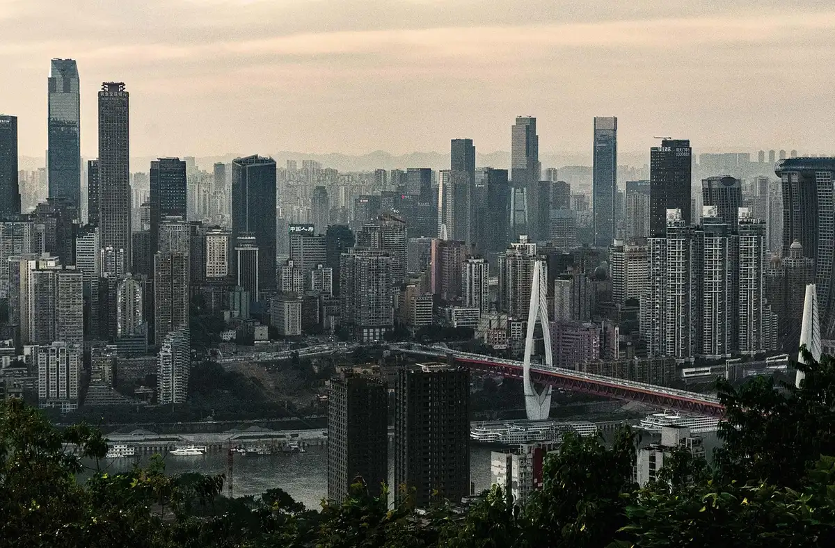 Vue panoramique depuis une suite de luxe en hauteur surplombant une métropole illuminée la nuit