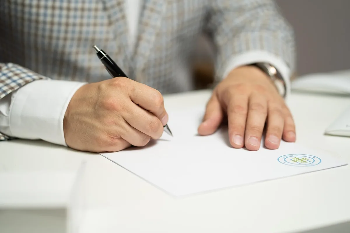 Chef d'entreprise signant une facture sur ordinateur