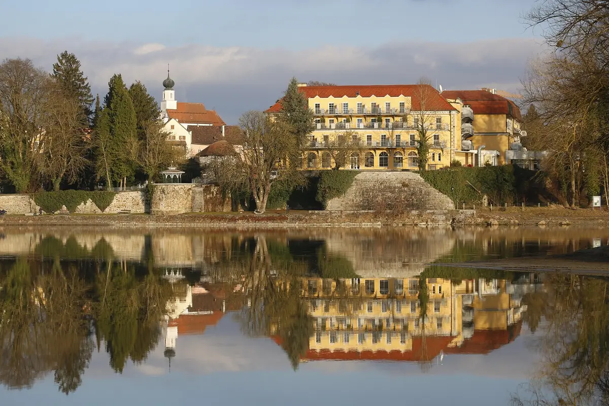 Randonneur léger vérifiant une carte devant une petite auberge ensoleillée