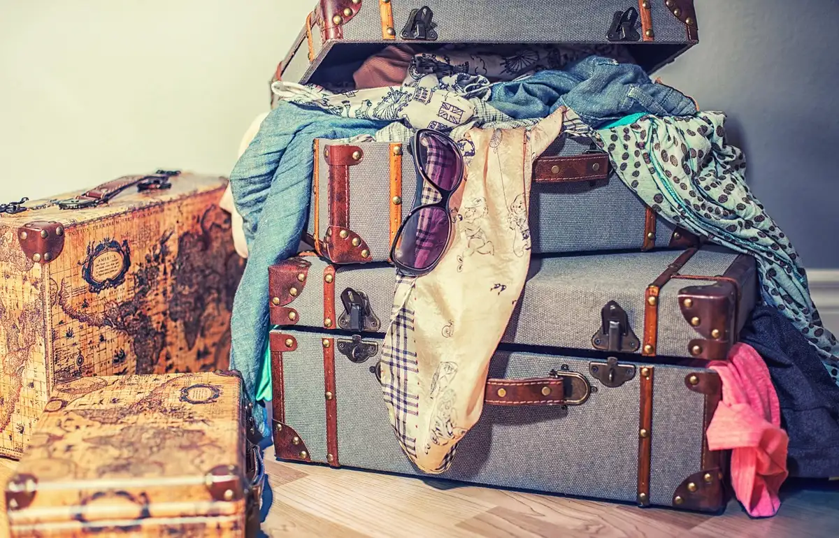 Main en train de rouler un t-shirt pour gagner de la place dans une valise