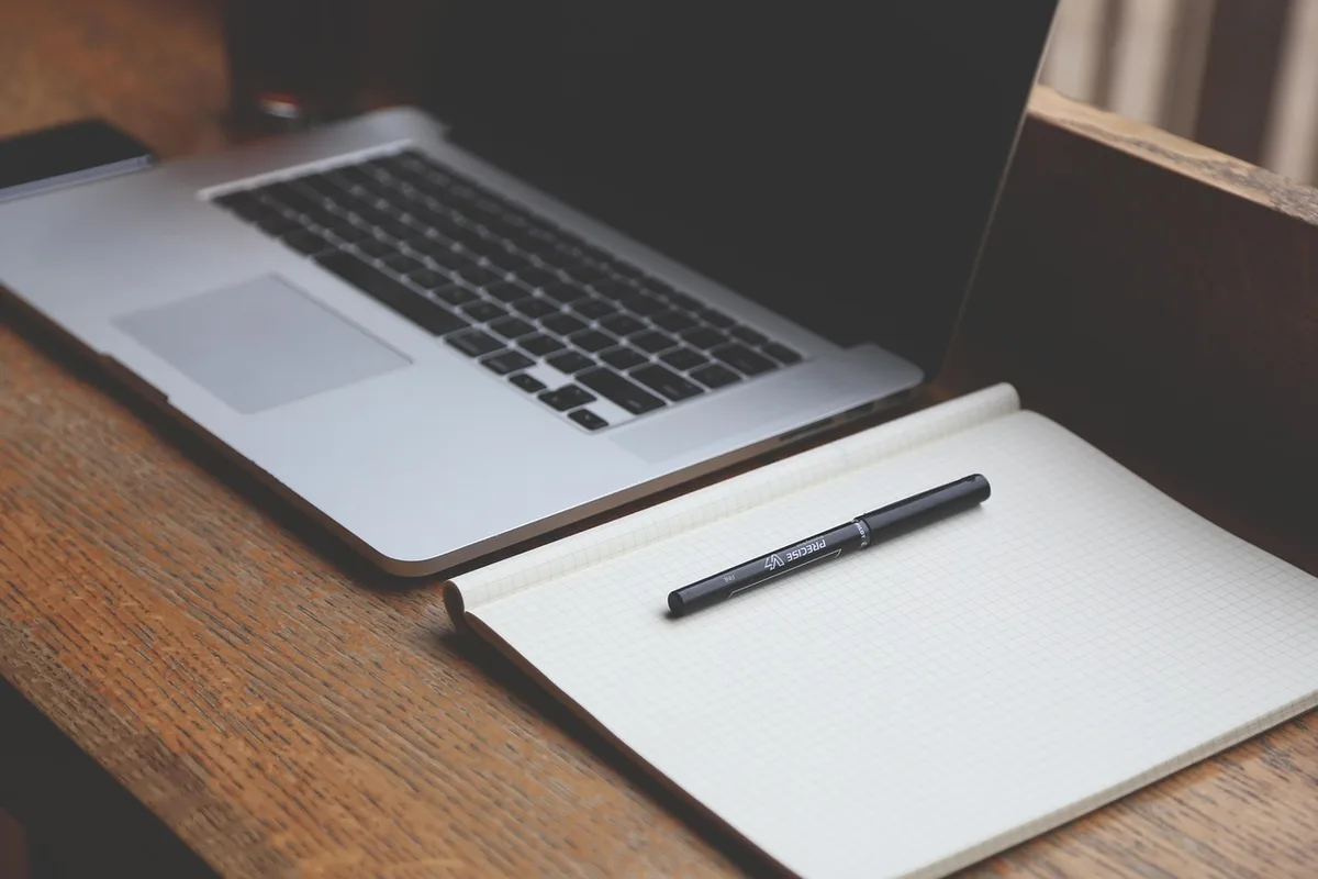 Checklist et documents de voyage posés sur un bureau lumineux