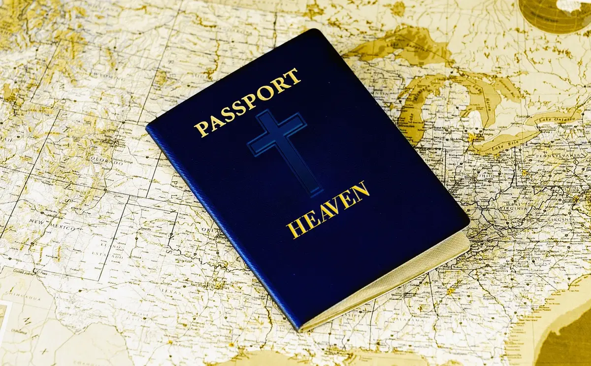 Carnet de voyage ouvert et passeport flou sur une table près d'une fenêtre en journée