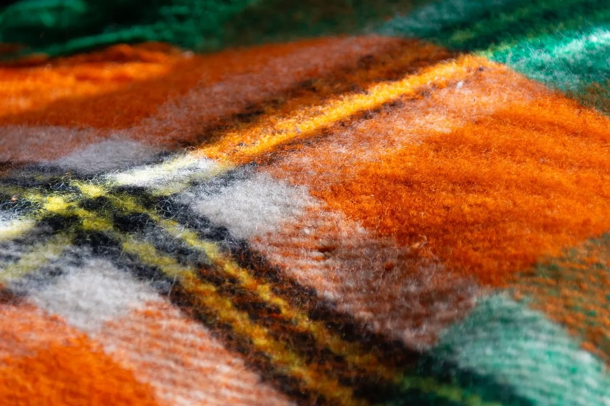 Intérieur cosy avec couverture en laine et cheminée prête à créer une atmosphère coorie