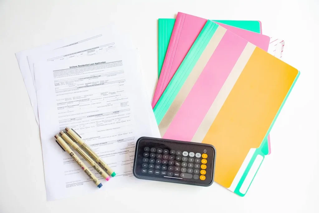 Documents de loyer et calculatrice sur un bureau près d'une fenêtre en pleine journée